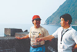 ロケ受け入れの可能性について語る佐藤さん（左）と板垣さん。後方の堤防では、ドラマ「HERO特別版」でキムタクが海へ飛び込むシーンが撮影された