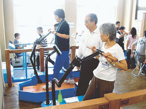 「健脳健身教室」でトレーニングに汗を流す受講者と小林教授（中央）